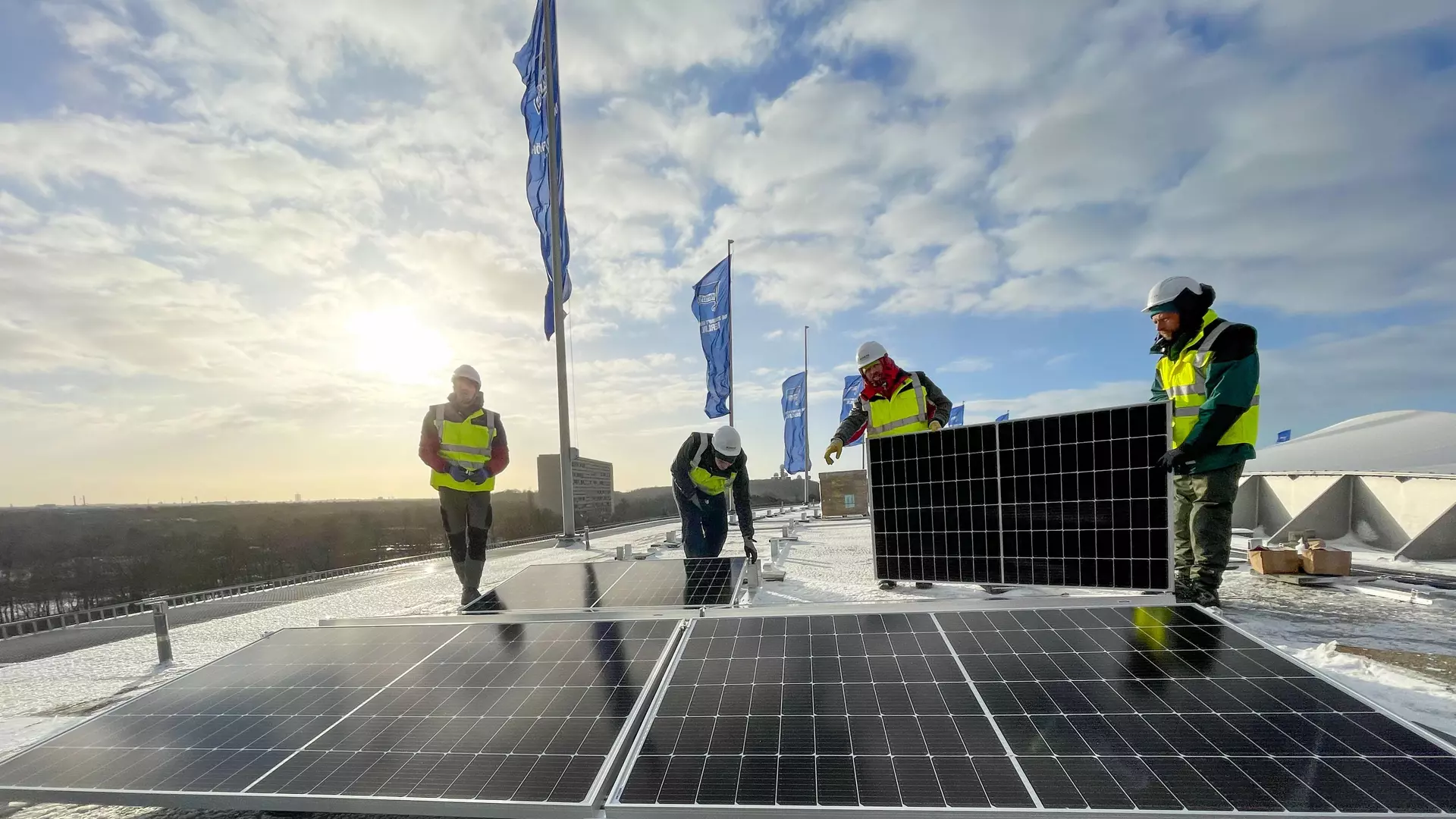 Installateure verlegen Solarmodule auf dem Olympiastadion Berlin 