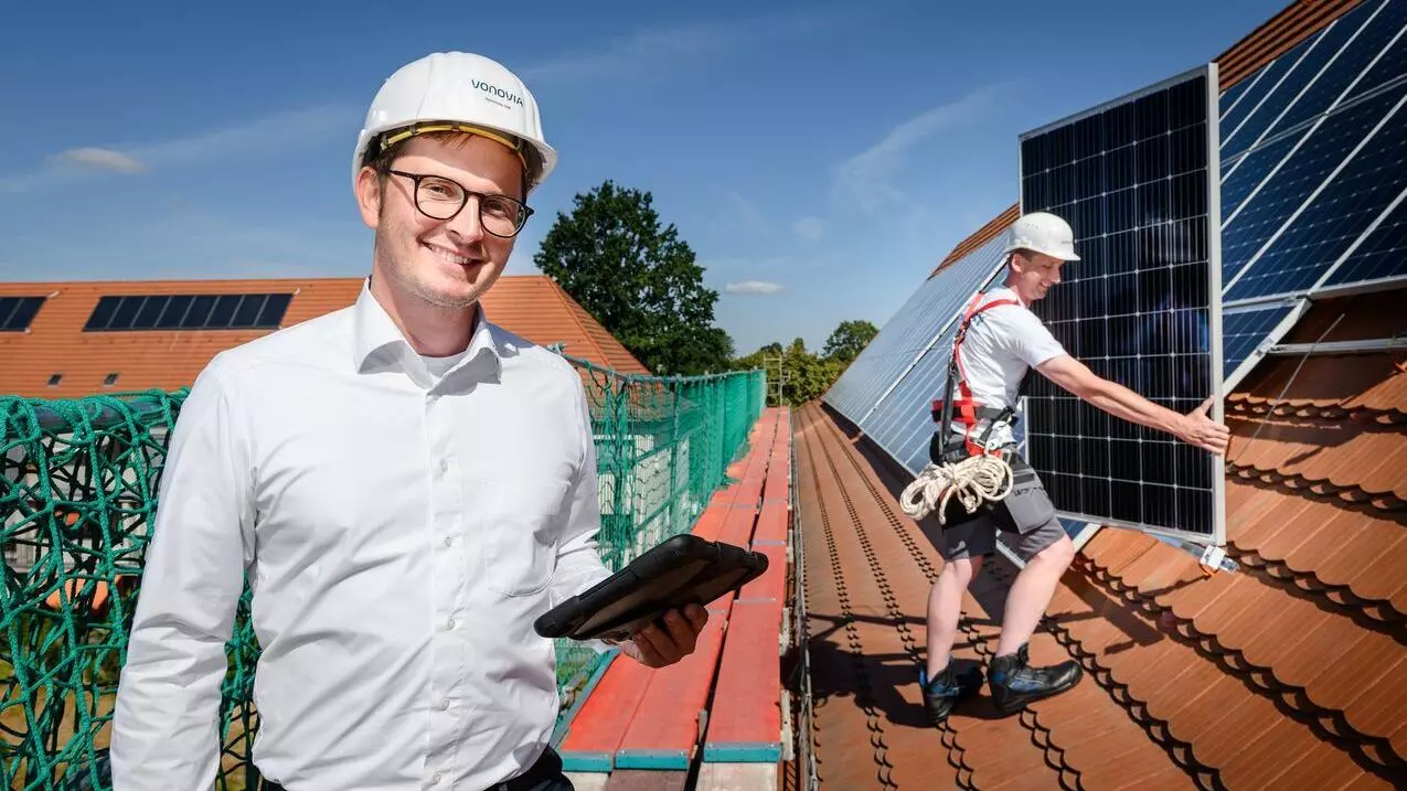 Mann installiert Solarmodule auf dem Dach